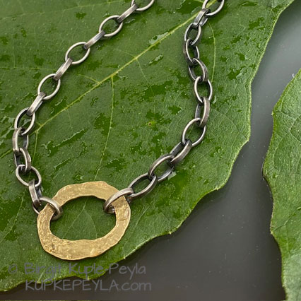 Gold oval necklace on figleaf
